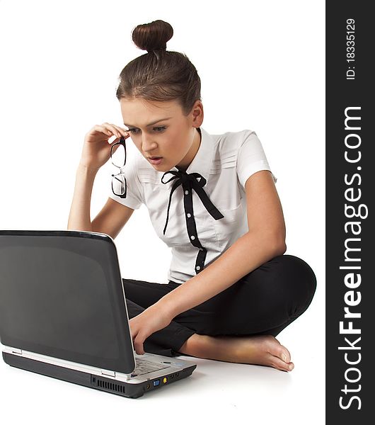 Beautiful girl sitting on the floor and works on a laptop keep the glasses in her hand isolated on white background Student Series