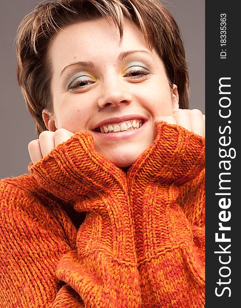Charming  beautiful woman in the sweater of orange color