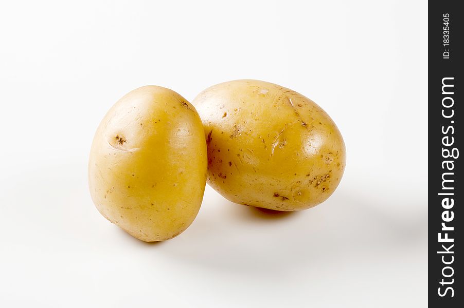 Two raw unpeeled new potatoes - studio