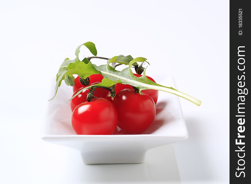 Bunch of fresh red tomatoes in a porcelain dish