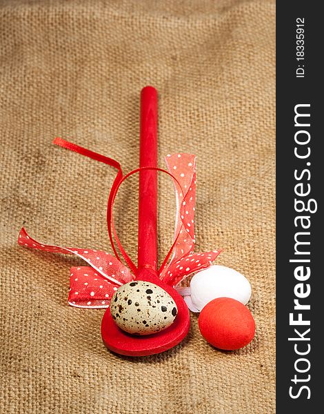 Easter eggs with red wooden spoon on sacking