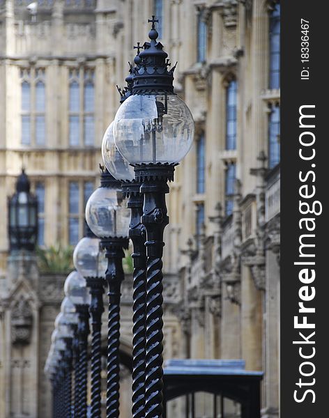 Decorative iron lamps stand in a row in front of Parliament building in London. Decorative iron lamps stand in a row in front of Parliament building in London.