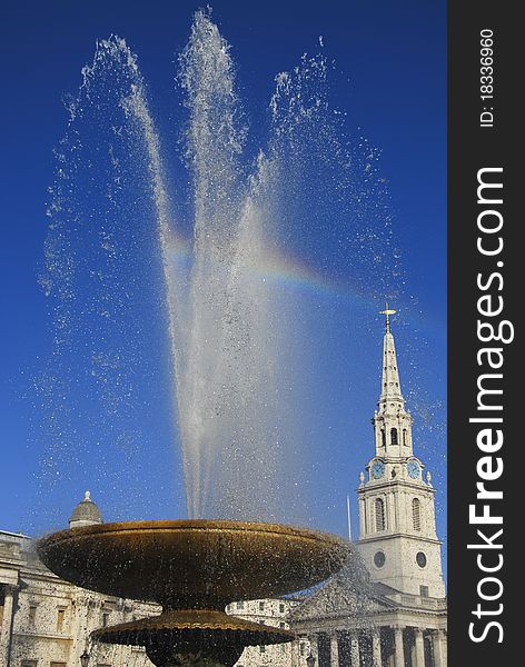 The spray from a fountain at Trafalgar Square in London creates a vibrant rainbow. The spray from a fountain at Trafalgar Square in London creates a vibrant rainbow