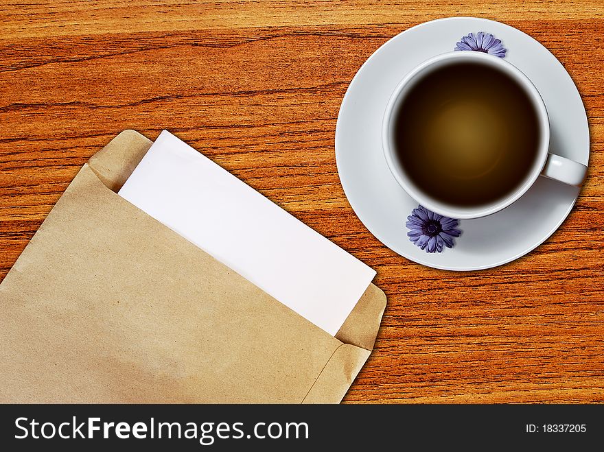 White cup of coffee and brown envelope document on wood table background