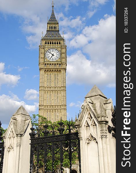 Big Ben clock tower in London stands behind decorative pillars and iron railings. Big Ben clock tower in London stands behind decorative pillars and iron railings.