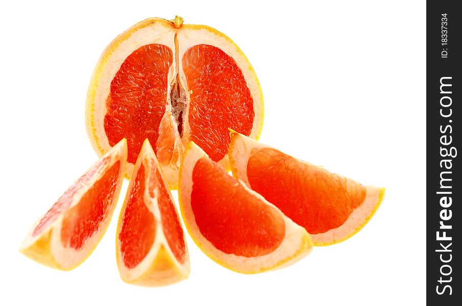 Half of grapefruit with four slices. Intentional shallow depth of field. Isolated on white background.