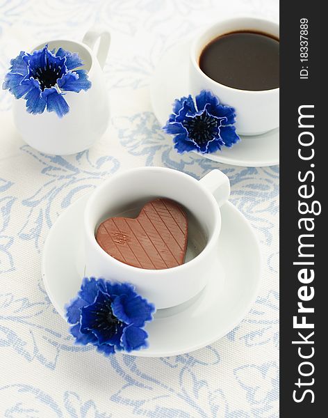 Chocolate heart, cup of coffee and cornflowers. Chocolate heart, cup of coffee and cornflowers