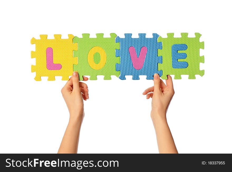 Teacher holding in the hand the amusing colored educational puzzles with the word love