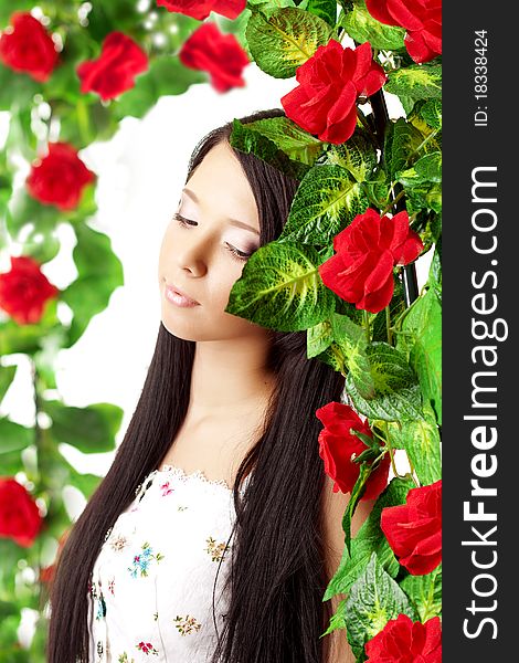 The image of a beautiful girl with bright make-up among the roses