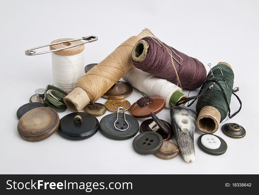 Thread and needles, buttons and pins on a white background