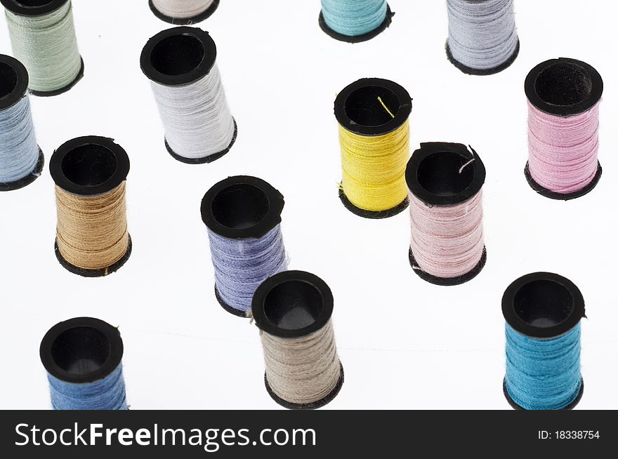 Spools of Thread Background with Many Colors on White.