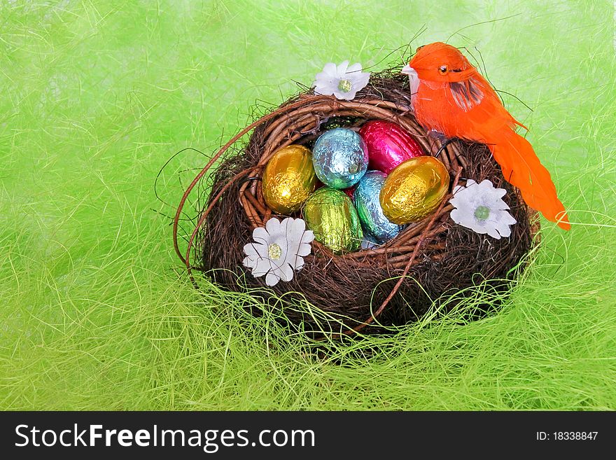 Chocolate eggs in the nest on the imitation of hay