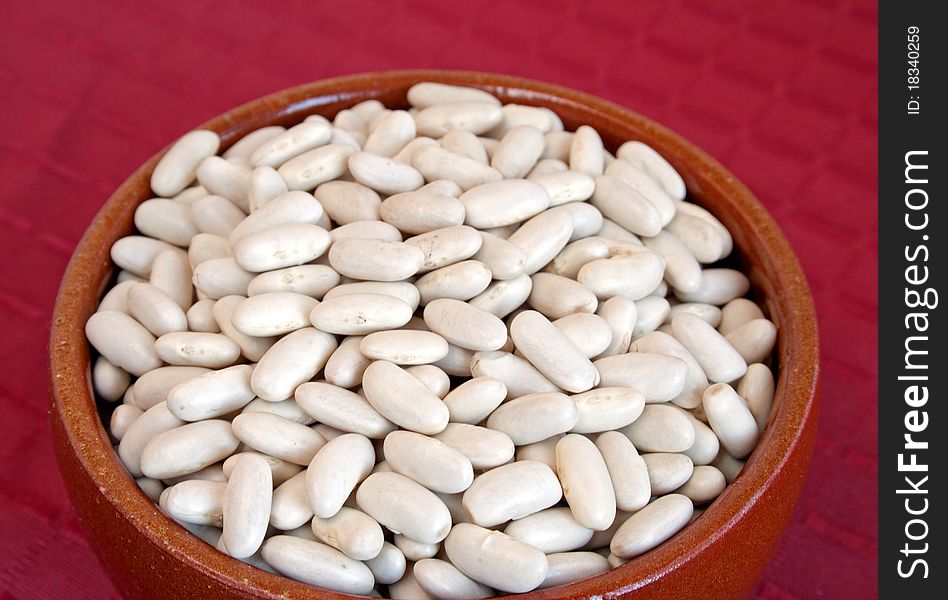 Raw white beans in ceramic bowl