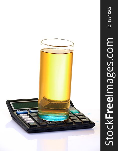 Glass full of petrol on calculator isolated on white background. Glass full of petrol on calculator isolated on white background.