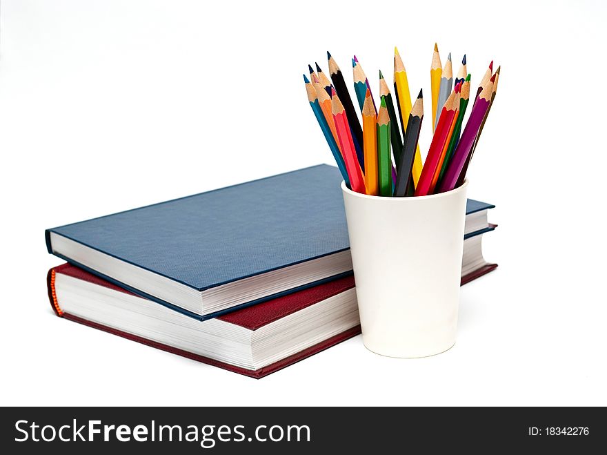 A stack of color books and pencils on the white background