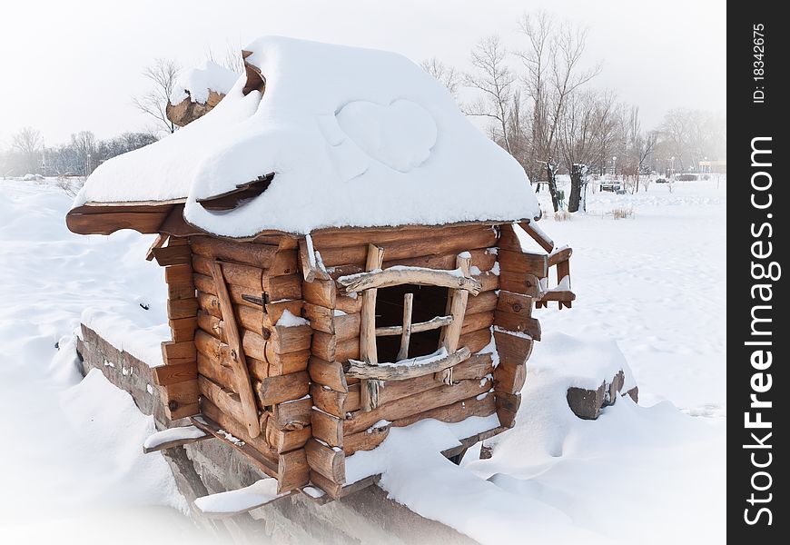 Wooden house covered with snow