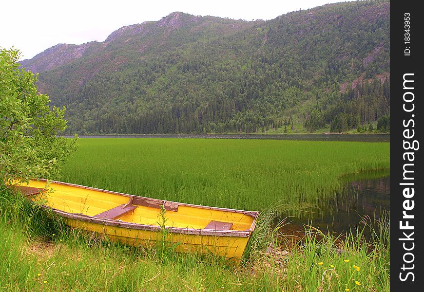 Old wooden boat on the lake bank