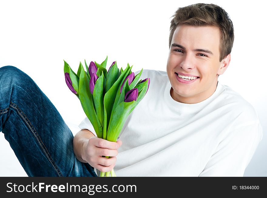 Handsome young man with a bouquet of tulips