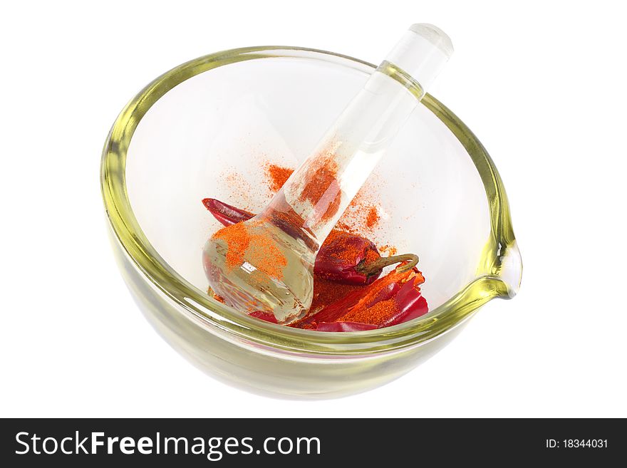 Dried red hot crumbly chili pepper in a colored glass mortar with pestle. Isolated on white. Dried red hot crumbly chili pepper in a colored glass mortar with pestle. Isolated on white.
