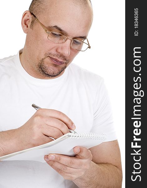 The man writes in a notebook on a white background