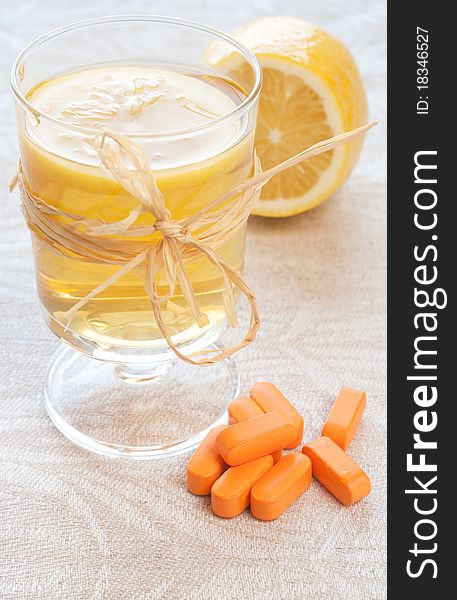 Mugs with chamomile tea, lemon, and pill