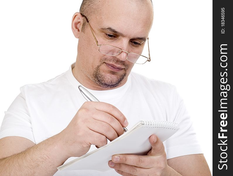 The man writes in a notebook on a white background