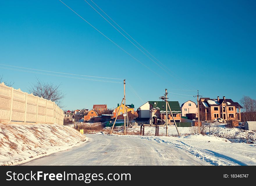 Winter season icy road to a countryside houses. Winter season icy road to a countryside houses