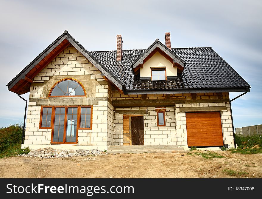 A newly constructed house with lots of roof detailing. A newly constructed house with lots of roof detailing.