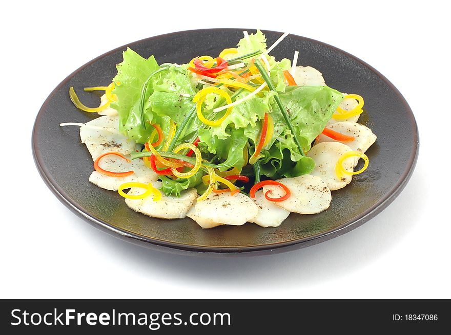 Salad with vegetables and fish close up on a white background