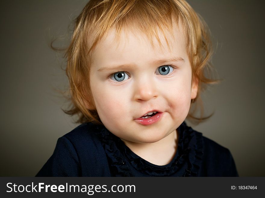 A little funny girl portrait on dark background