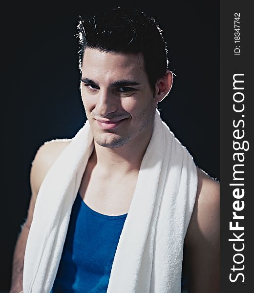 Portrait of confident caucasian male in sportswear, looking at camera and smiling on black background. Vertical shape, waist up, front view. Portrait of confident caucasian male in sportswear, looking at camera and smiling on black background. Vertical shape, waist up, front view