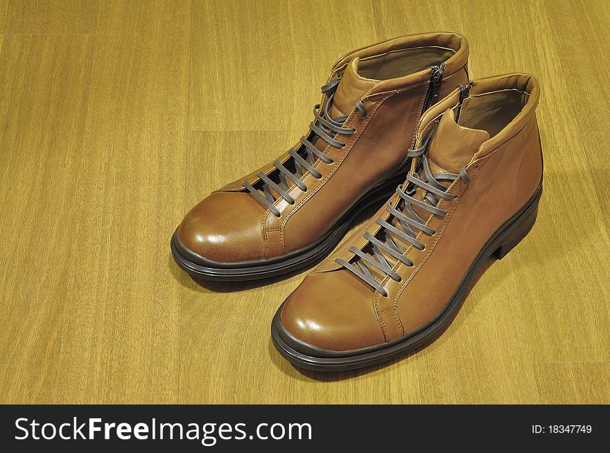 New brown boots on a wooden background. New brown boots on a wooden background