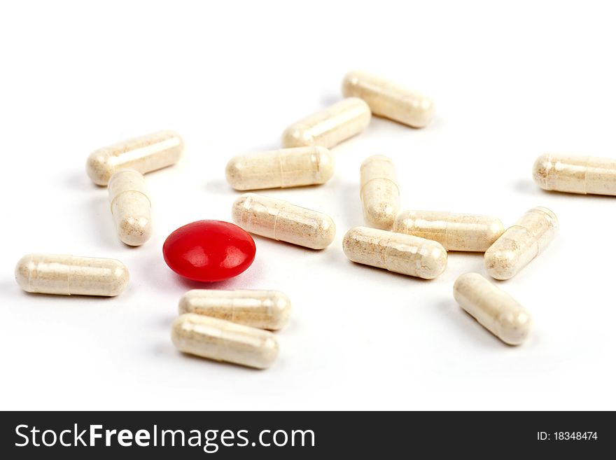 Red Capsule And Pills On White Background