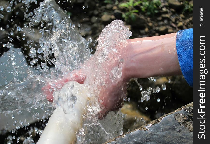 Closeup view of mountain spring water on the hand. Closeup view of mountain spring water on the hand