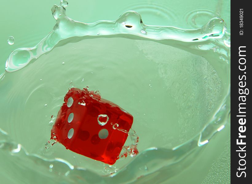 A red dice droped in water.
