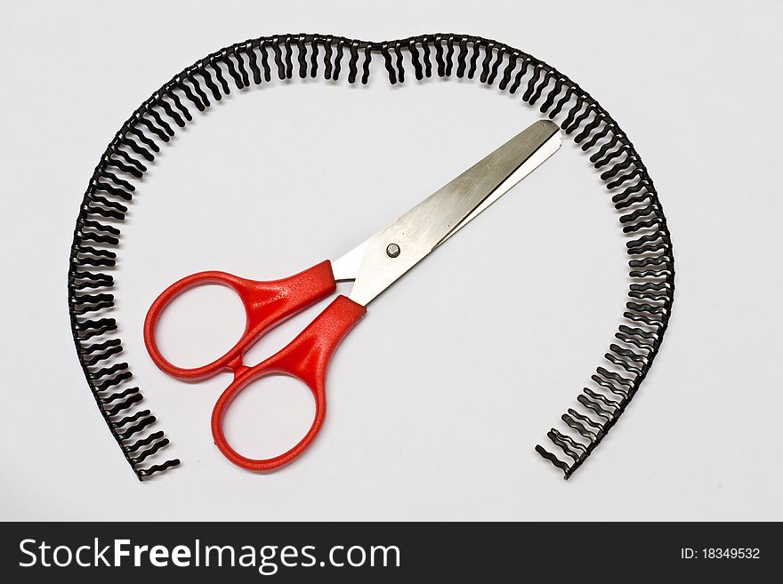 Scissors handle red background with a black headdress covering is placed. Scissors handle red background with a black headdress covering is placed