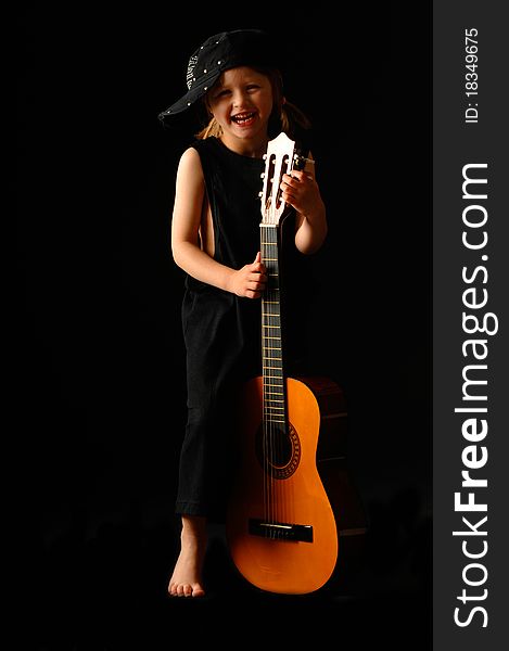 School aged girl with classic guitar on black background. School aged girl with classic guitar on black background