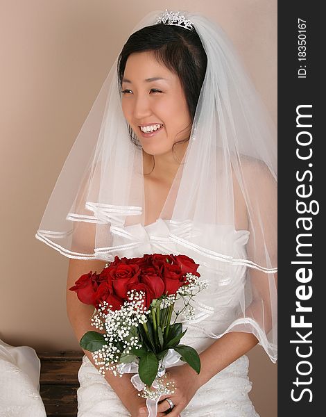 Beautiful bride wearing a traditional gown with red roses