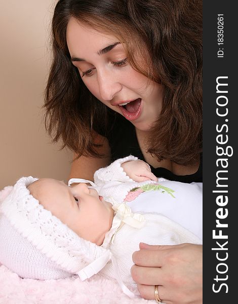 Beautiful brunette mother looking at her two month old baby girl. Beautiful brunette mother looking at her two month old baby girl