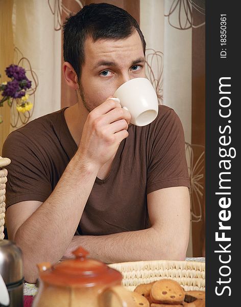 Young Guy With Tea And Rusk In The Kitchen