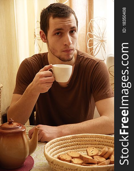 Young Guy With Tea And Rusk In The Kitchen