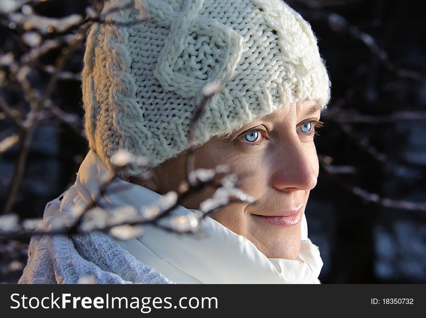 Blue-eyed woman in white in the winter forest. closeup, portrait