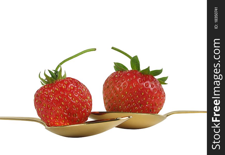 Strawberry in gold spoons on a white background. Clipping path