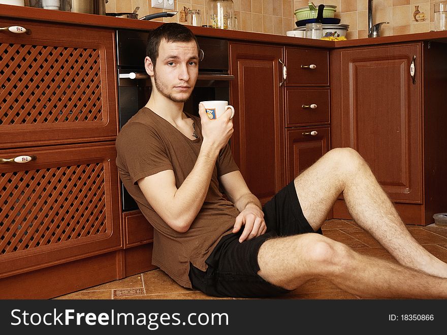 Young Guy With Tea And Rusk In The Kitchen