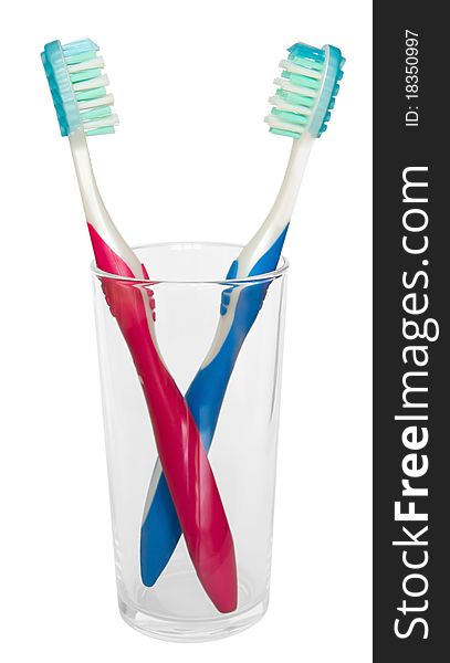 Two tooth brushes in glass. Isolated on white background. Clipping path. Two tooth brushes in glass. Isolated on white background. Clipping path.