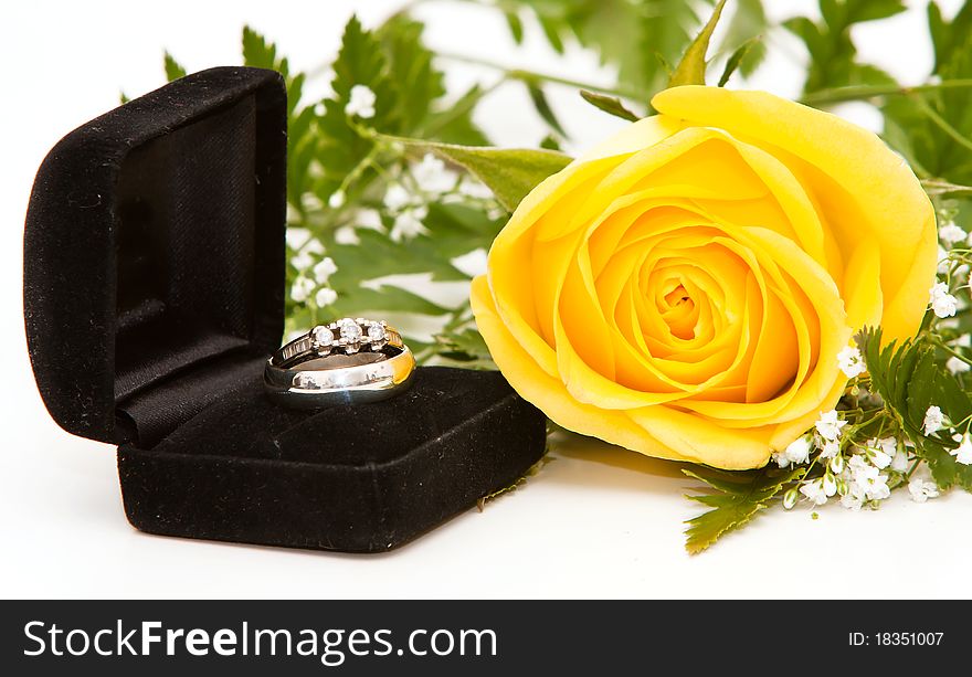 A diamond ring and yellow rose. A diamond ring and yellow rose