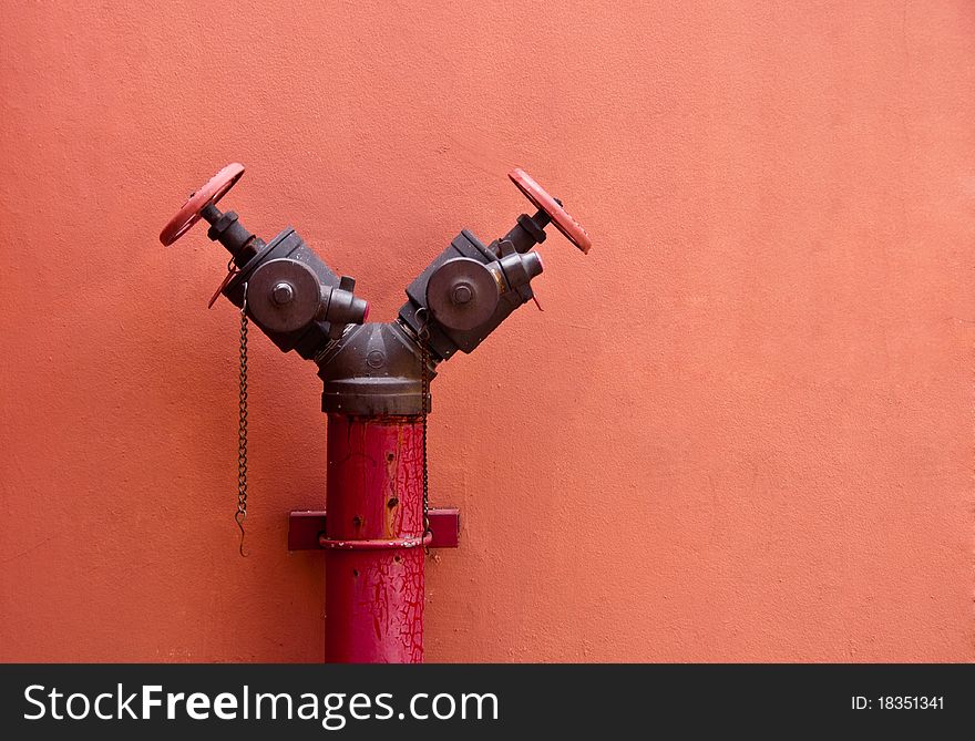 Old fire hydrant on red wall