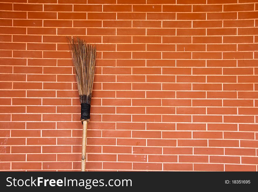 Broom on red brick wall. Broom on red brick wall