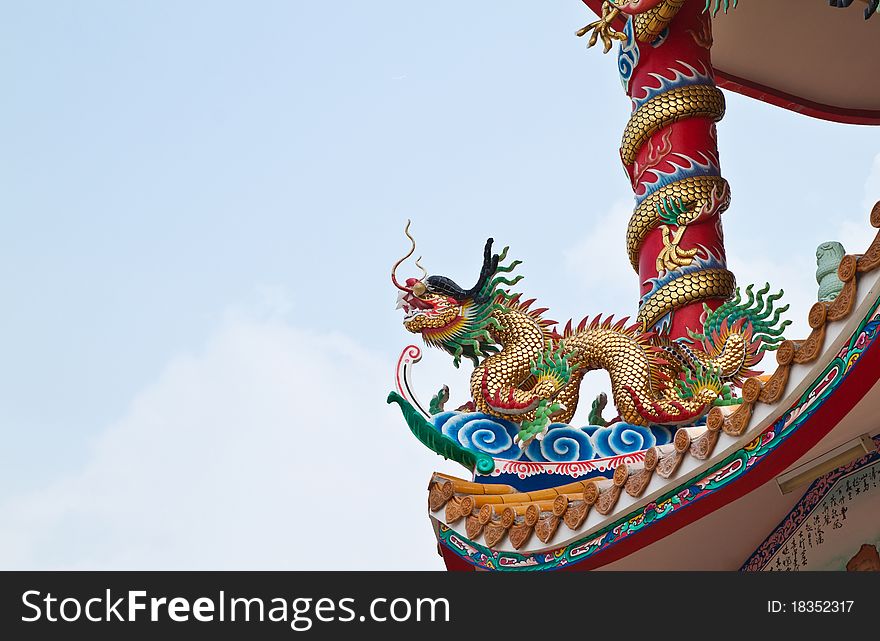 Dragon sculpture on roof of chinese shrine and the blue sky,East of Thailand