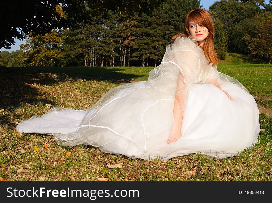 Young beautiful woman posing in a white dress in the nature. Young beautiful woman posing in a white dress in the nature